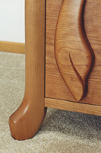 Carved cherry dresser leg and drawer detail